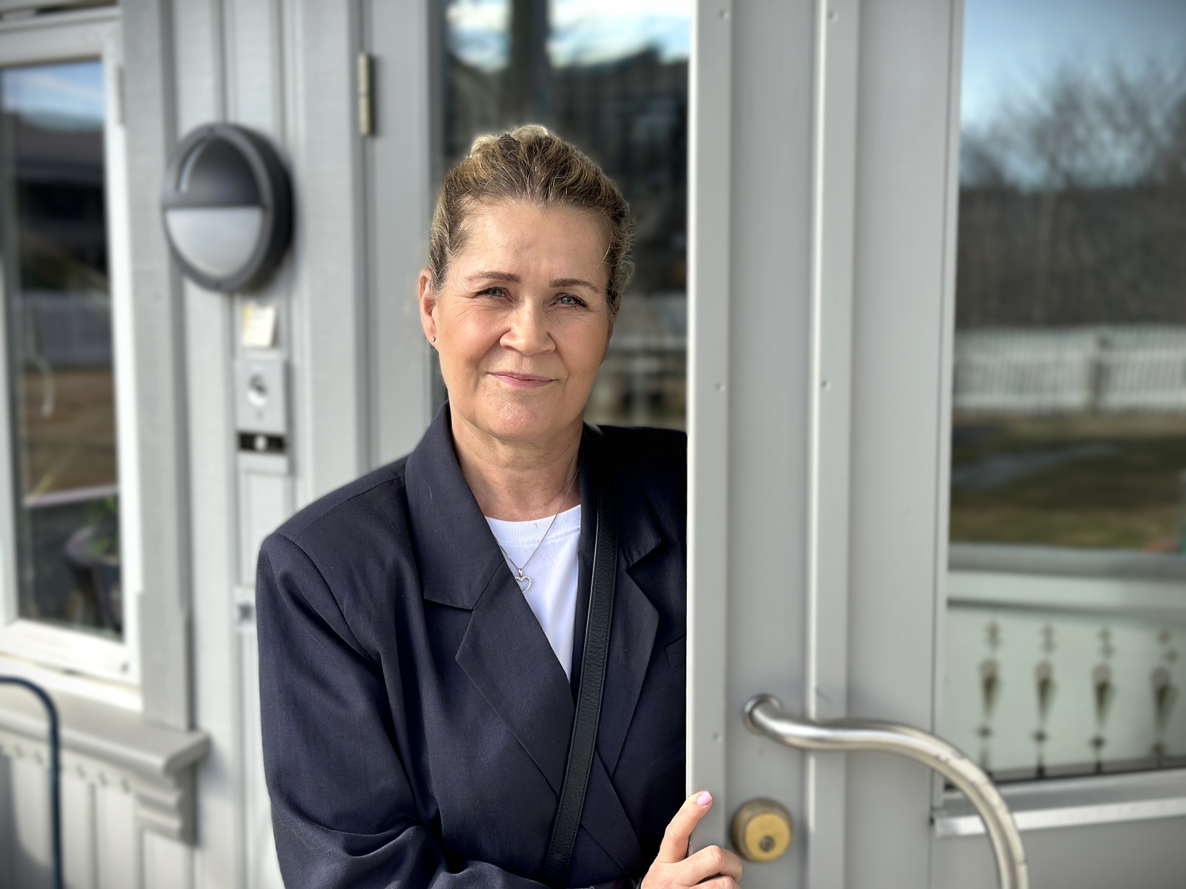 Bildet viser lederen av Ringerike krisesenter. Hun står i inngangsdøra til huset.