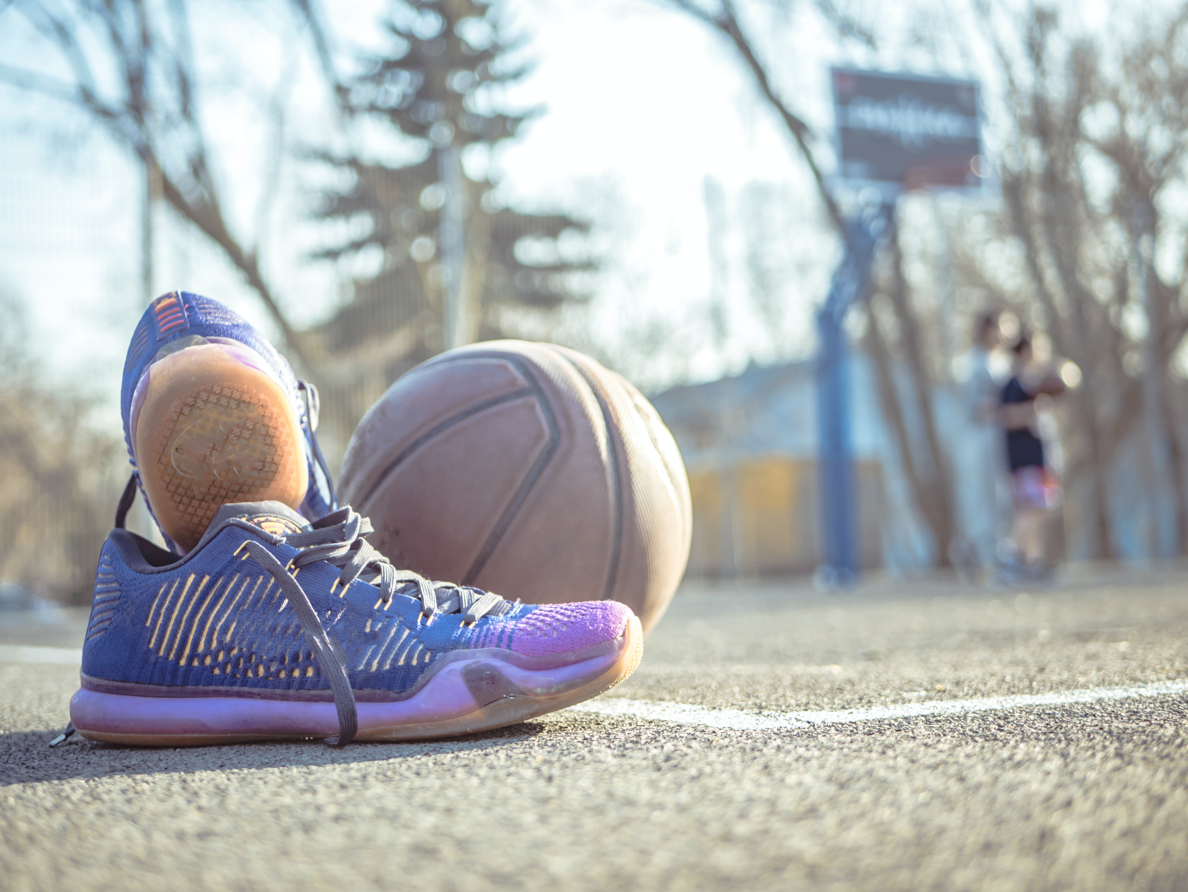 Bildet viser et par joggesko som står på en basketballbane.